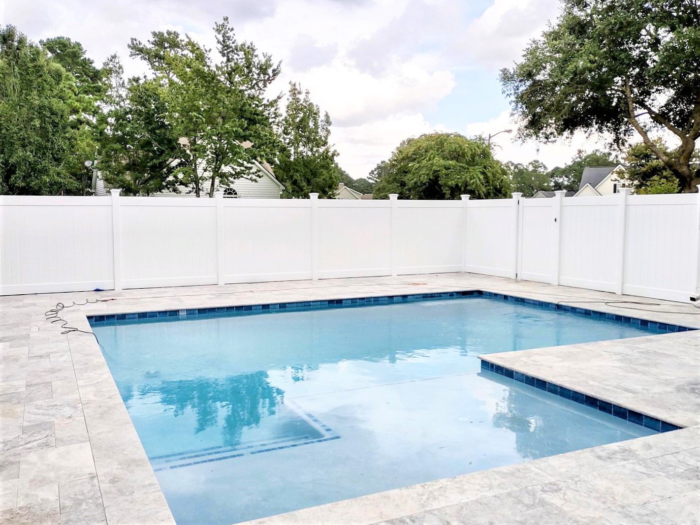 Photo of a white vinyl privacy pool fence