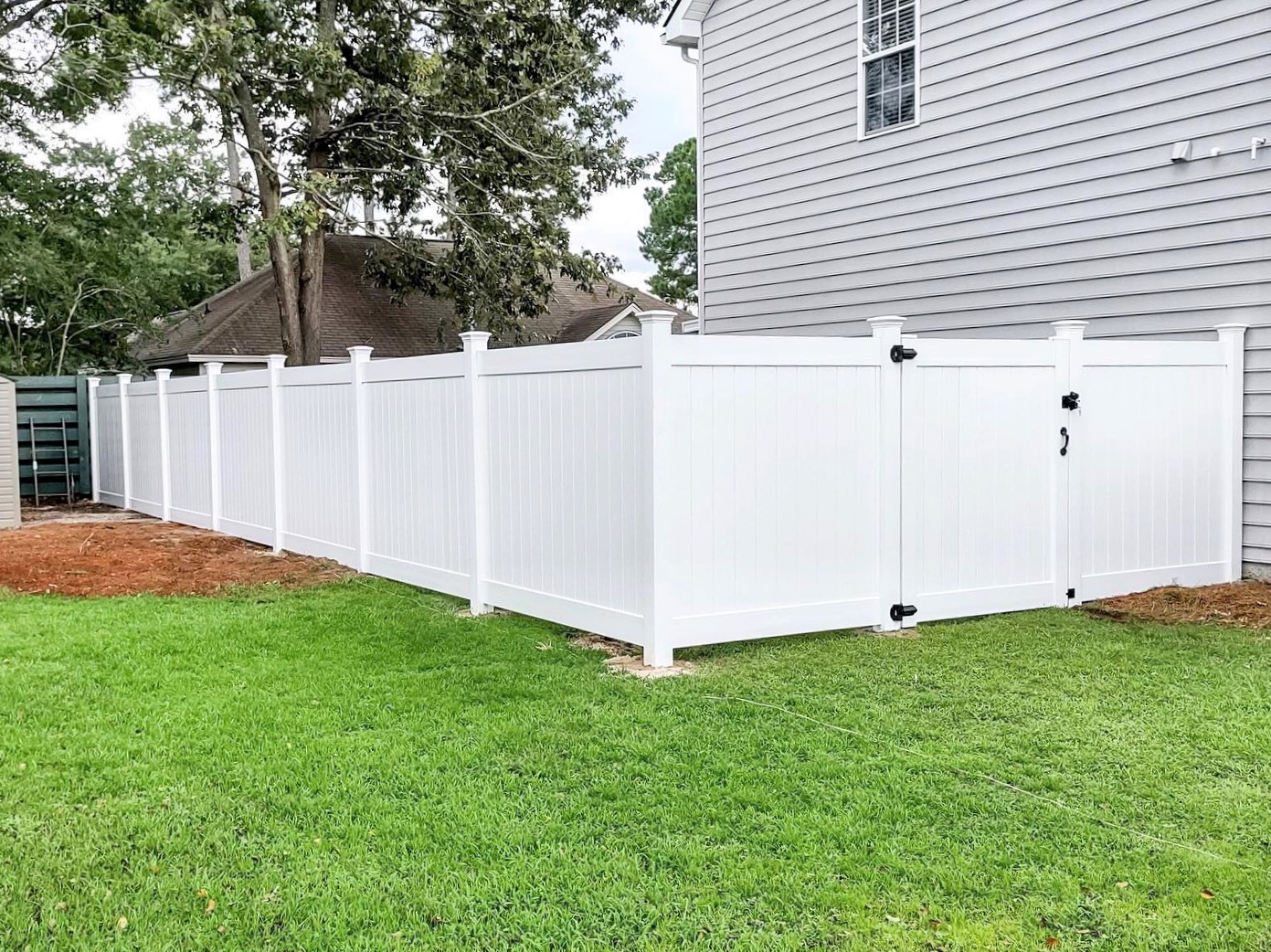 Photo of a white vinyl privacy fence