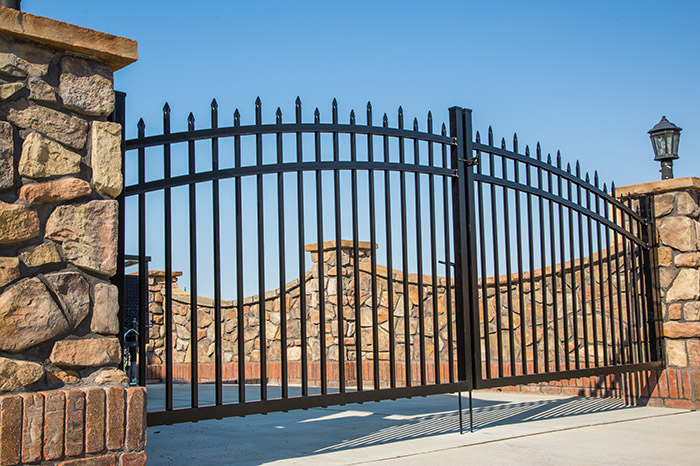 Photo of an aluminum fence gate connected by stone posts