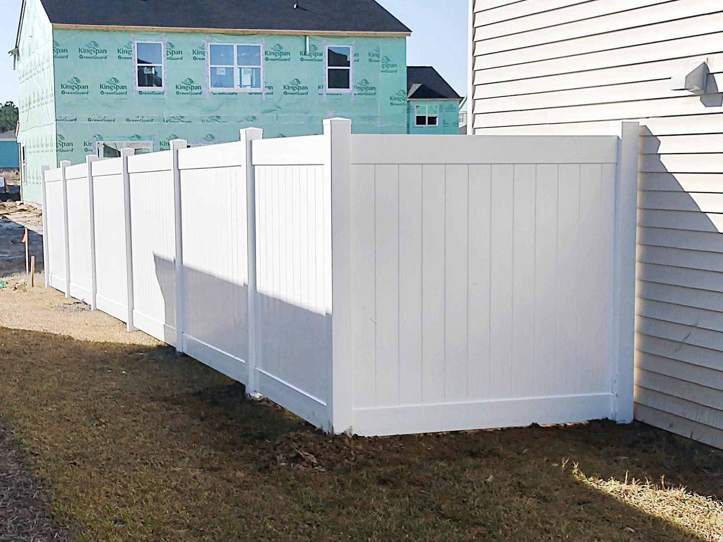 Photo of a white vinyl privacy fence